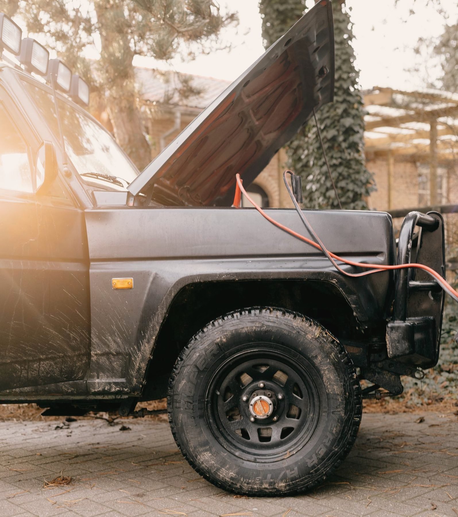 Jumper cables clamped to a vehicle battery terminal